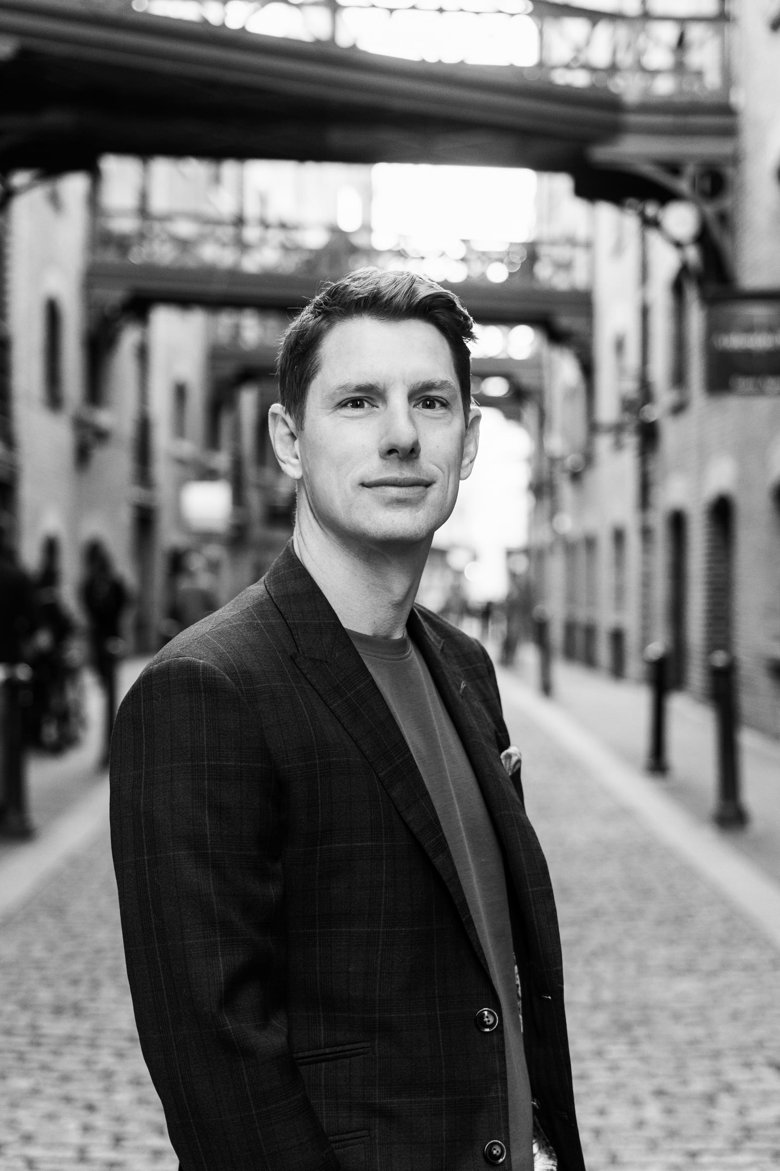 Marcus Higgins, black and white portrait in a cobblestone alley